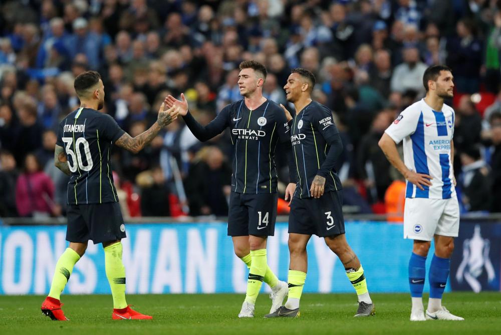 Manchester City’s Nicolas Otamendi, Danilo and Aymeric Laporte celebrate after the match as Brighton’s Florin Andone looks dejected   during their FA Cup semifinal at Wembley Stadium, London, Saturday. — Reuters