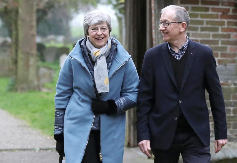 


Britain’s Prime Minister Theresa May and her husband Philip on Sunday leave church, as Brexit turmoil continues, near High Wycombe, Britain. — Reuters