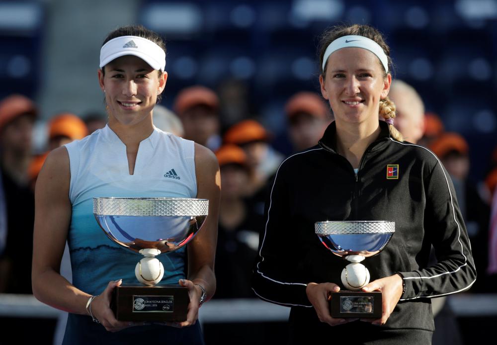 Spain’s Garbine Muguruza (L) celebrates winning the Monterrey Open with the trophy alongside runner-up Belarus’ Victoria Azarenka Sunday. — Reuters 