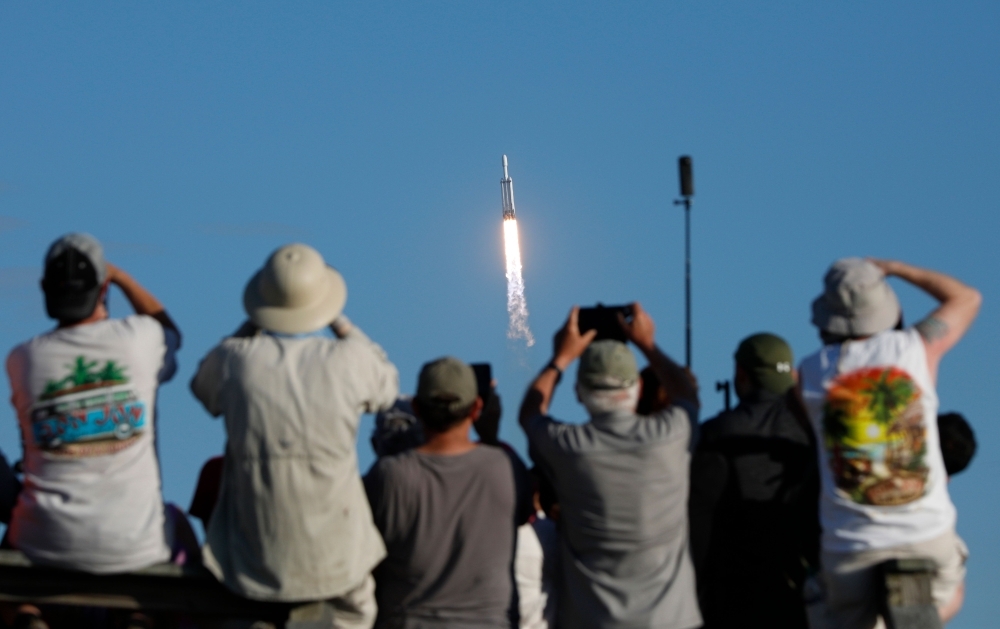 Visitors at Playalinda Beach look on as a SpaceX Falcon Heavy rocket launches from Pad 39B at the Kennedy Space Center in Florida, on Thursday.  SpaceX's Falcon Heavy ferried the Arabsat-6A communications satellite into orbit for Saudi Arabia in the first commercial mission of the world's most powerful rocket. — AFP