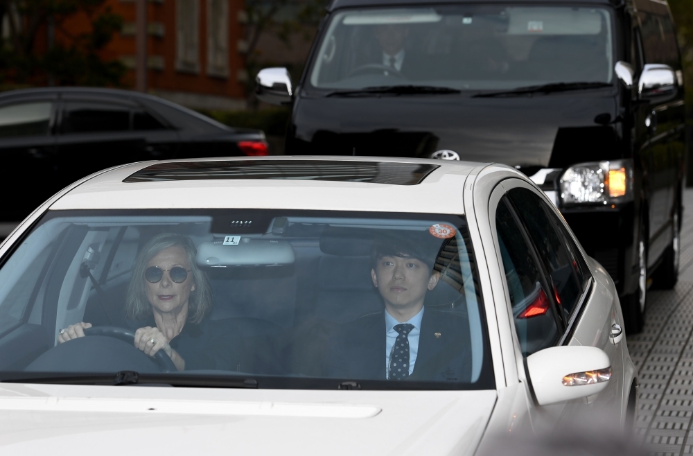 Sho Kosasa, right, an assistant defense lawyer for former Nissan boss Carlos Ghosn, rides in a motorcade believed to be carrying Carole Ghosn, the wife of Carlos Ghosn, as it leaves the Tokyo district court in Tokyo on Thursday. — AFP