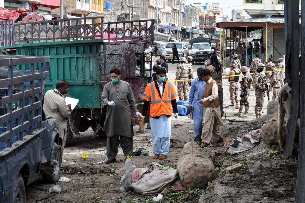 Pakistani security officials inspect the site of a bomb blast at a fruit market in Quetta on Friday. — AFP