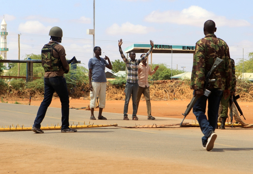 Security officers question civilians at a roadblock near the scene where gunmen abducted two Cuban doctors as they were going to work, in Mandera county, Kenya, on Friday. — Reuters