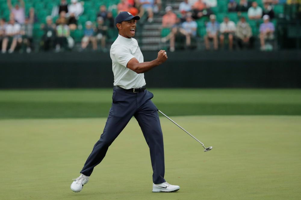 Tiger Woods of the US celebrates a birdie putt on the 15th hole during second round play of the Augusta National Masters Golf Friday. — Reuters