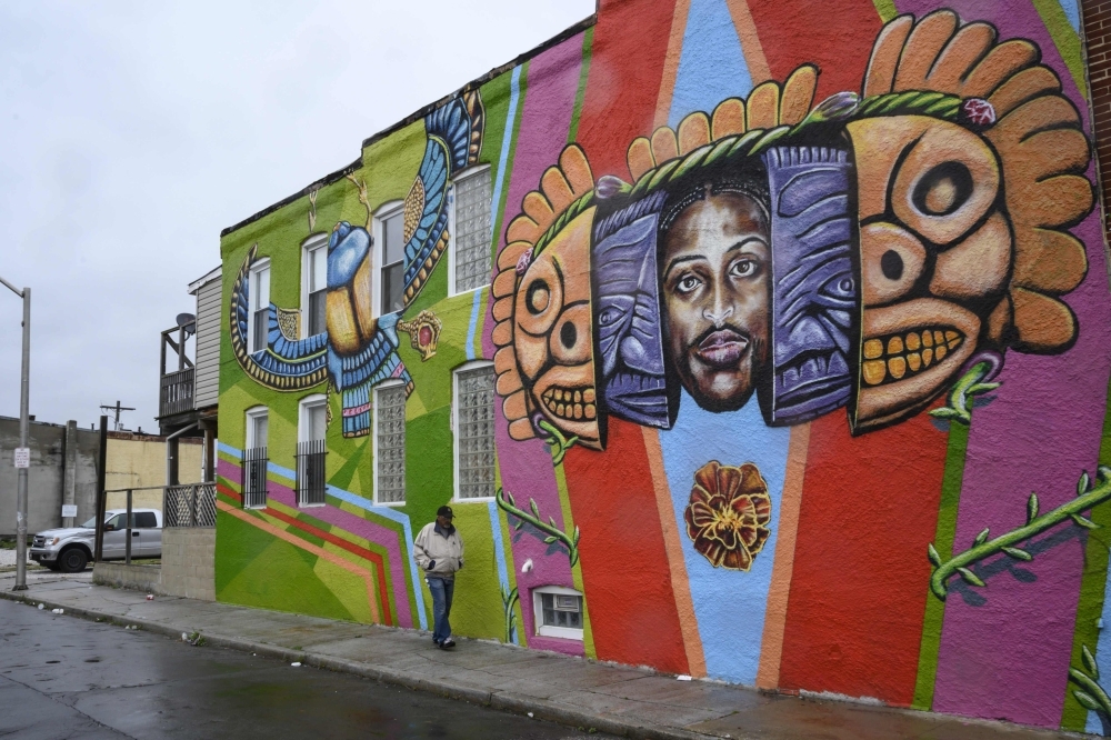 A man walks by a mural painting on a rainy day in the McElderry Park area in Baltimore, Maryland, in this April 12, 2019  file photo. — AFP