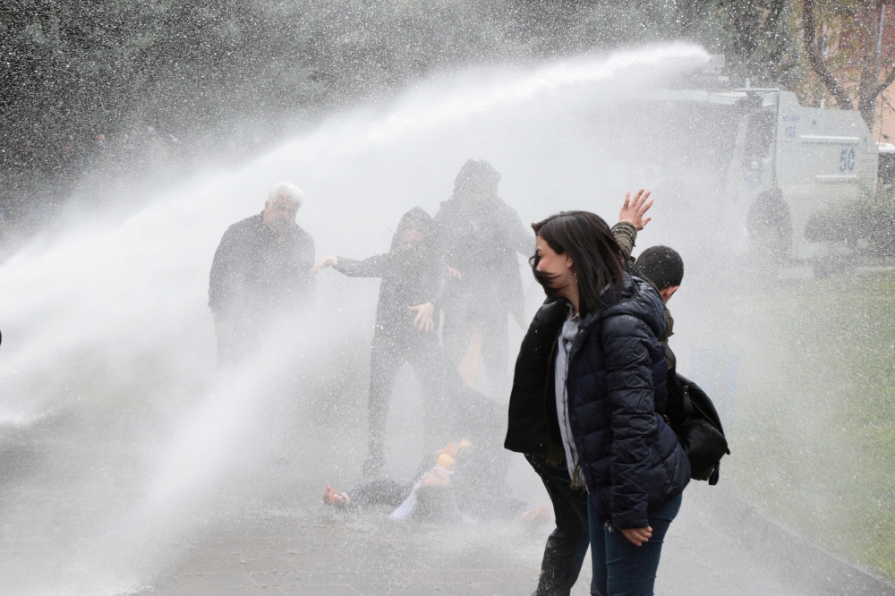 Pro-Kurdish Peoples’ Democratic Party (HDP) lawmaker Remziye Tosun falls after being hit by a police water cannon during a protest against results of the local elections, in Diyarbakir, Turkey, on Wednesday. — Reuters