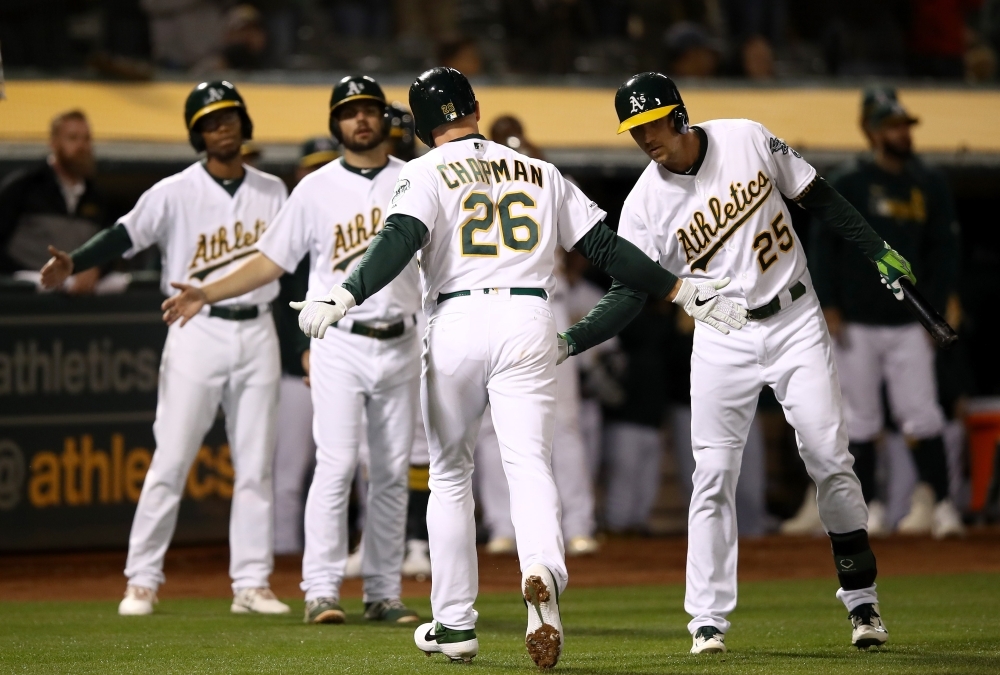 Matt Chapman No. 26 of the Oakland Athletics is congratulated by Stephen Piscotty No. 25 after he hit a home run off of Wade Miley No. 20 of the Houston Astros in the sixth inning at Oakland-Alameda County Coliseum on Wednesday in Oakland, California. — AFP