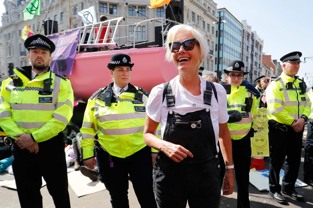 British actress Emma Thompson, center, gestures as police surround the pink boat being used as a stage by climate change activists as they occupy the road junction at Oxford Circus in central London on Friday during the fifth day of an environmental protest by the Extinction Rebellion group. — AFP