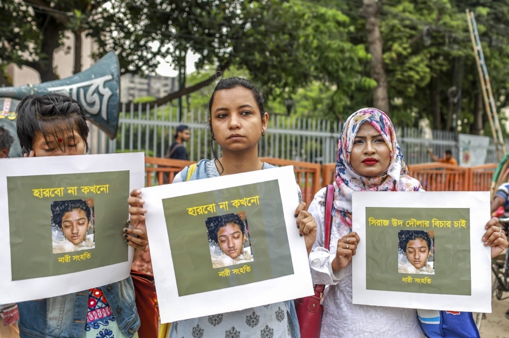 Bangladeshi women hold placards and photographs of schoolgirl Nusrat Jahan Rafi at a protest in Dhaka on April 12, 2019 following her murder by being set on fire after she had reported a sexual assault. — AFP