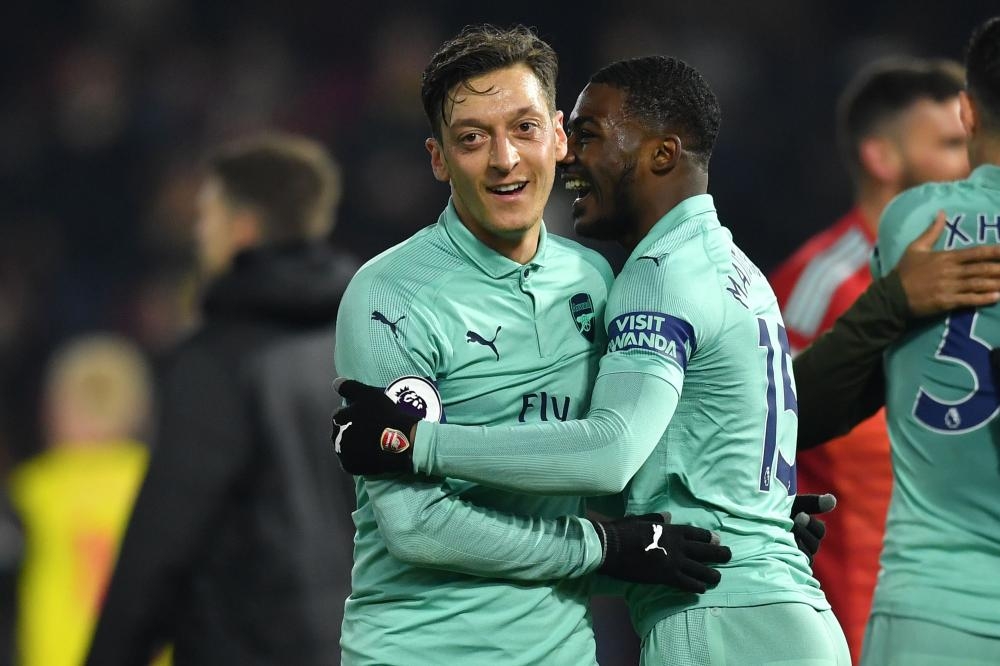 Arsenal’s midfielder Mesut Ozil (L) celebrates with teammate Ainsley Maitland-Niles after their English Premier League football match against Watford at Vicarage Road Stadium in Watford Monday. — AFP