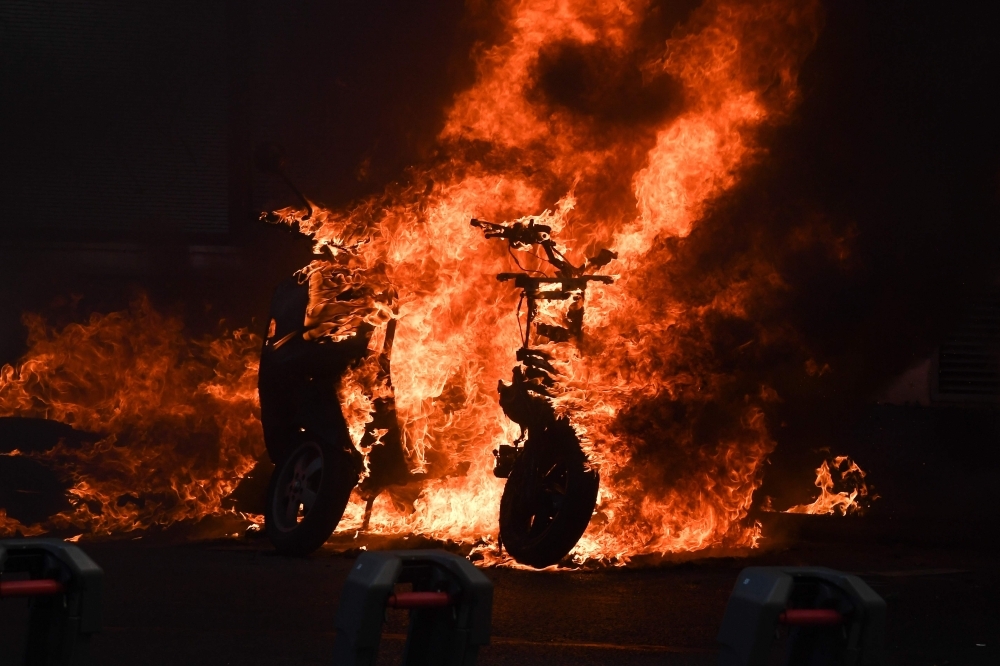 A picture shows a scooter set ablaze during an anti-government demonstration called by the “Yellow Vests” movement in Paris on Saturday.  — AFP
