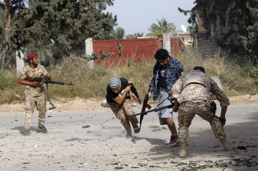 Libyan fighters loyal to the Government of National Accord (GNA) run as they fire their guns during clashes with forces loyal to strongman Khalifa Haftar south of the capital Tripoli's suburb of Ain Zara, Saturday. — AFP