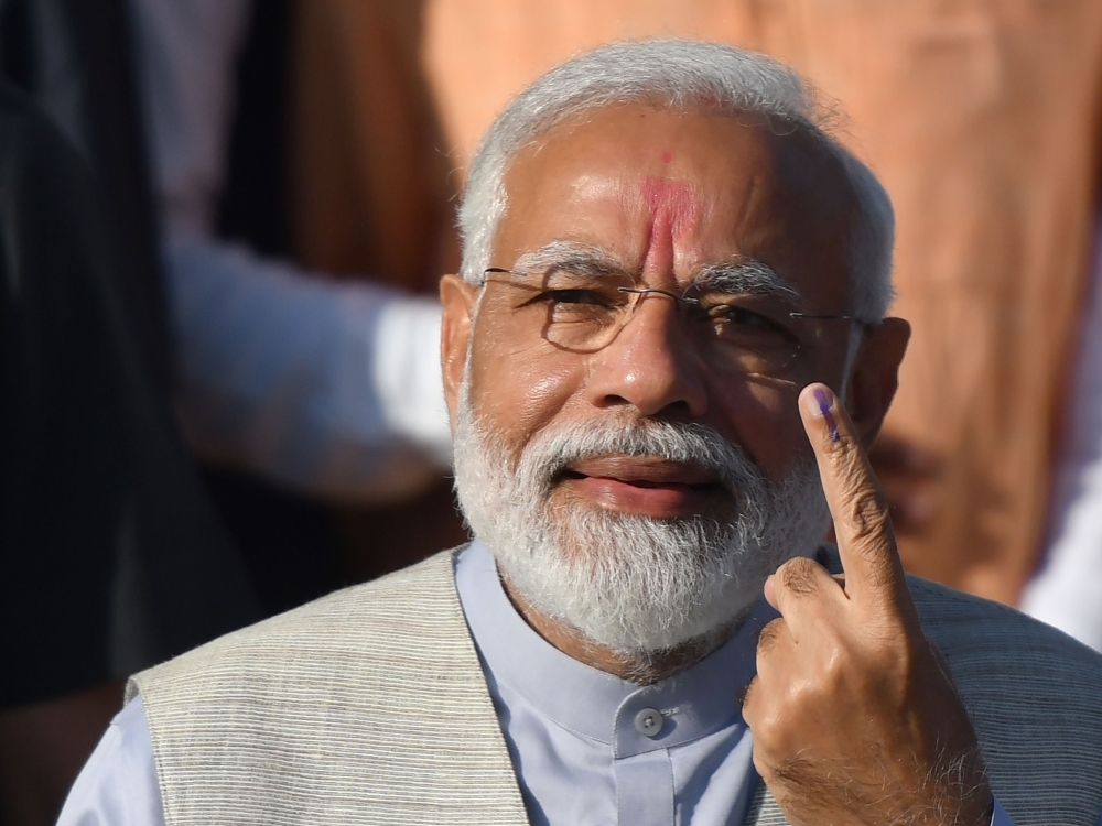 Indian Prime Minister Narendra Modi displays his ink-marked finger after casting his vote during the third phase of general elections at a polling station in Ahmedabad, Gujarat, on Tuesday. — AFP