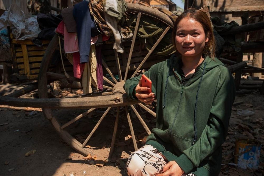 Cambodian farmer Yin Socheat, 29, poses with her cellphone in Tmat Paelly village, Cambodia, in this March 14, 2019 file photo. — Thomson Reuters Foundation