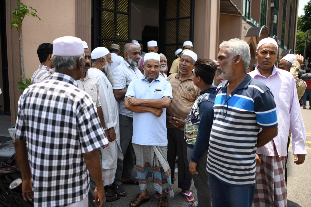 Members of the Sri Lanka Muslim community gather outside a mosque after prayers in Colombo on Tuesday. — AFP
