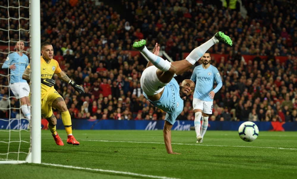 Manchester City's Brazilian goalkeeper Ederson (2L) watches as City's Belgian defender Vincent Kompany clears the ball during the English Premier League football match against Manchester United at Old Trafford in Manchester, north west England, on Wednesday. — AFP
