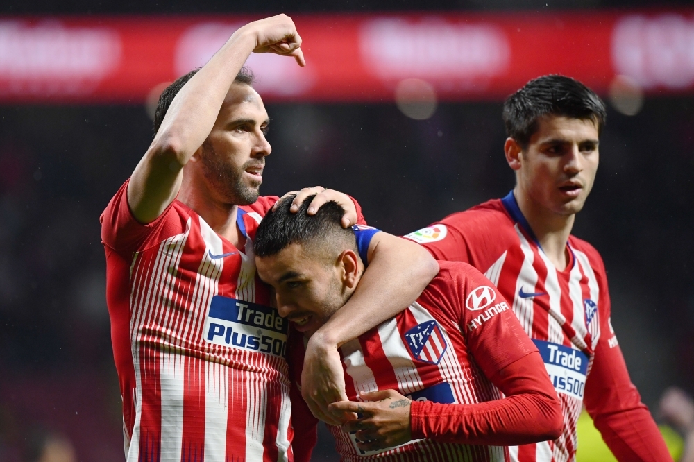 TOPSHOT - Atletico Madrid's Argentinian forward Angel Correa (C) is congratulated for his goal by Atletico Madrid's Uruguayan defender Diego Godin (L) during the Spanish league football match between Club Atletico de Madrid and Valencia CF at the Wanda Metropolitano stadium in Madrid on April 24, 2019. / AFP / GABRIEL BOUYS                     
