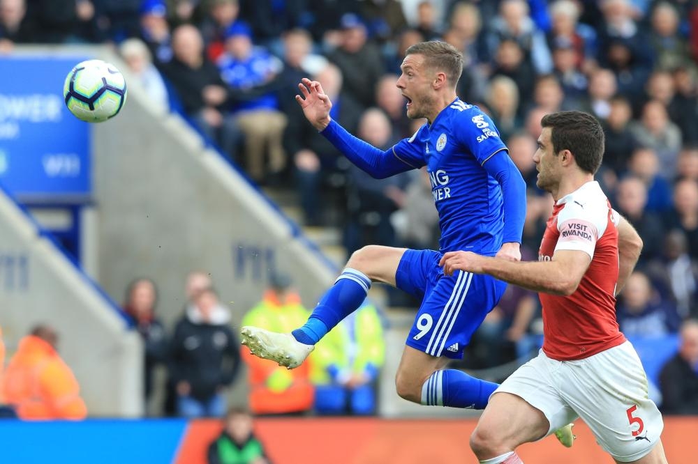 Leicester City’s striker Jamie Vardy (L) lobs the ball over the Arsenal goalkeeper to score their second goal during the English Premier League football match at King Power Stadium in Leicester Sunday. — AFP