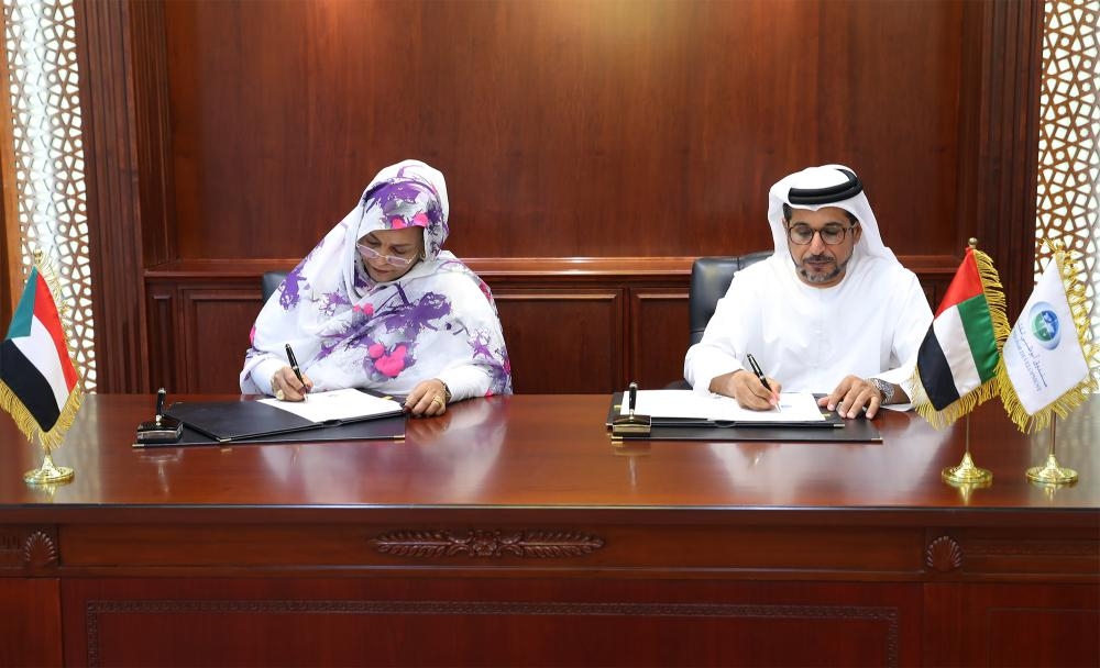 Mohammed Saif Al Suwaidi, Director General of ADFD, and Amna Mirgani Hassan, General Manager of the Capital Markets Department of CBOS, sign the agreement 