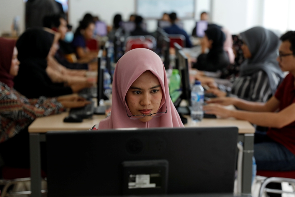 A volunteer looks to the monitor as she inputs data of vote tally forms, of this month’s election, in a room at Joko Widodo’s national campaign team office in Jakarta, Indonesia, on Monday. — Reuters