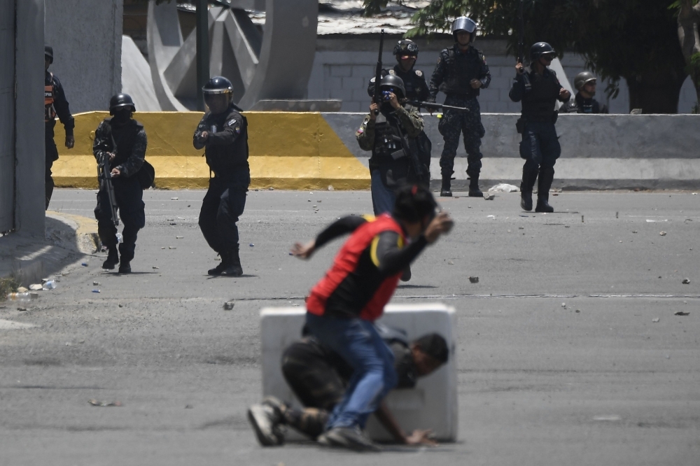 Opposition demonstrators clash with soldiers loyal to Venezuelan President Nicolas Maduro after troops joined opposition leader Juan Guaido in his campaign to oust Maduro’s government, in the surroundings of La Carlota military base in Caracas, on Tuesday. — AFP