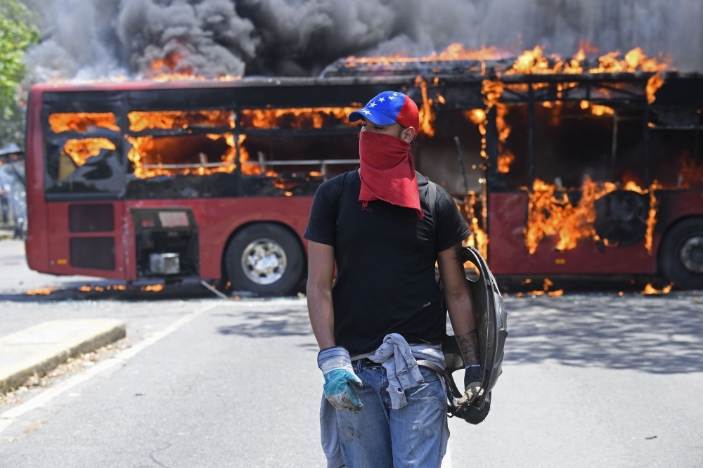 Opposition demonstrators clash with soldiers loyal to Venezuelan President Nicolas Maduro after troops joined opposition leader Juan Guaido in his campaign to oust Maduro’s government, in the surroundings of La Carlota military base in Caracas, on Tuesday. — AFP