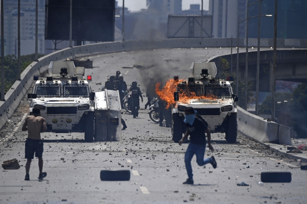 Opposition demonstrators clash with soldiers loyal to Venezuelan President Nicolas Maduro after troops joined opposition leader Juan Guaido in his campaign to oust Maduro’s government, in the surroundings of La Carlota military base in Caracas, on Tuesday. — AFP
