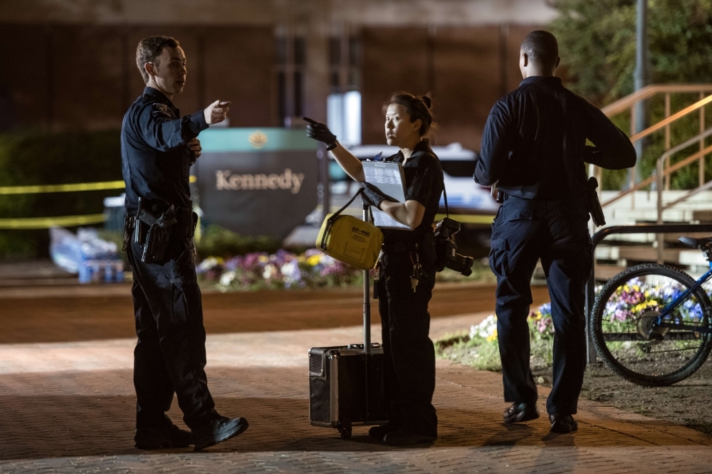 Charlotte-Mecklenburg crime scene investigators talk in front of the Kennedy building where a gunman killed two people and injured four students at UNC Charlotte in Charlotte, North Carolina, on Wednesday. — AFP