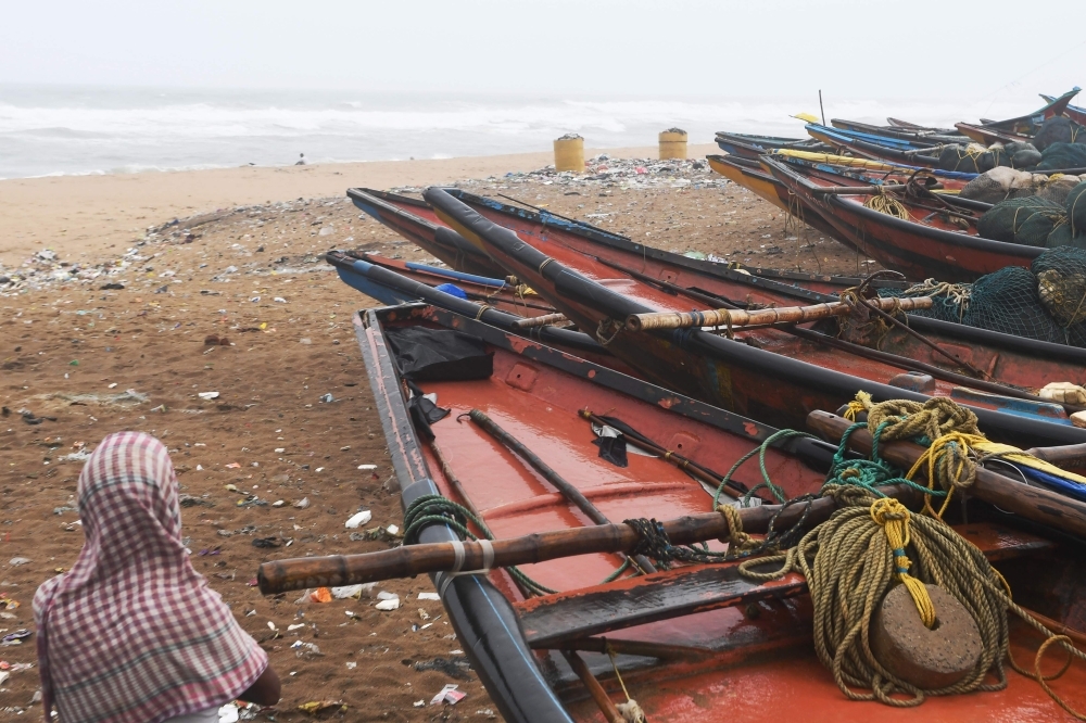 Indian fisherman looks out next to fishing boats in Puri in the eastern Indian state of Odisha on Thursday, as cyclone Fani approaches the Indian coastline. — AFP