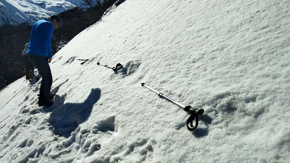 In this file handout photo taken on April 9, 2019 by the Indian Army, Indian men measure large footprints in the snow, sighted by the Indian Army, near the Makalu Base Camp in the northeastern Himalayas. — AFP