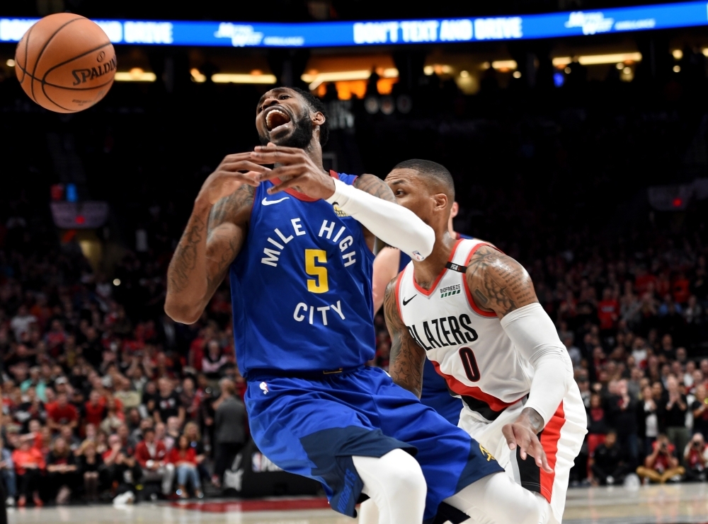 Damian Lillard No. 0 of the Portland Trail Blazers pokes the ball away from Will Barton No. 5 of the Denver Nuggets during the second half of game three of the Western Conference Semifinals at Moda Center on Friday in Portland, Oregon. The Blazers won 140-137 in 4 overtimes. — AFP