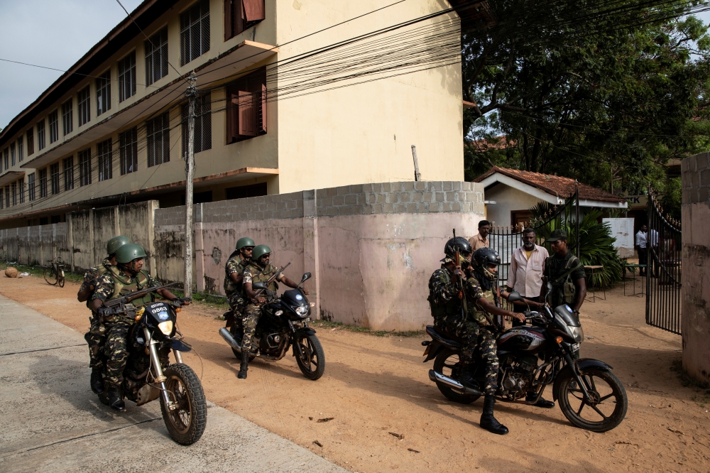 Soldiers on patrol arrive at a school which opened days after a string of suicide bomb attacks across the island on Easter Sunday, in Batticaloa, Sri Lanka, on Monday. — Reuters