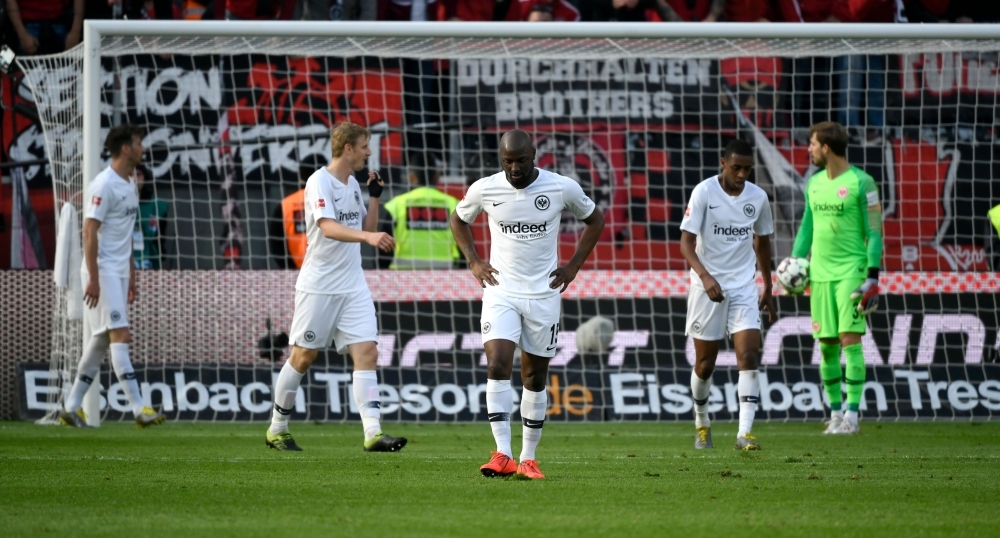 Eintracht Frankfurt's players react after scoring an own goal during the German first division Bundesliga football match against Bayer Leverkusen in Leverkusen, western Germany on Sunday. — AFP