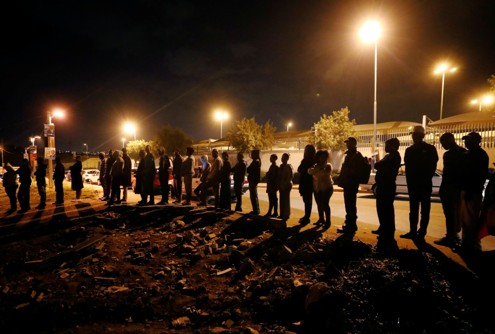 Voters queue to cast their ballots as night falls outside a polling station in Alexandra township in Johannesburg, South Africa, on Wednesday. — Reuters