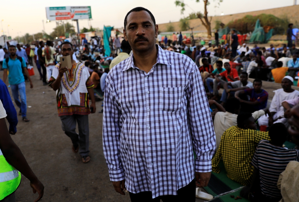 Ahmed Rabie, a member of the Sudanese Professionals Association (SPA), poses as he arrives to break his Ramadan fast with his friends in front of the Defense Ministry compound in Khartoum, Sudan, on Tuesday. — Reuters