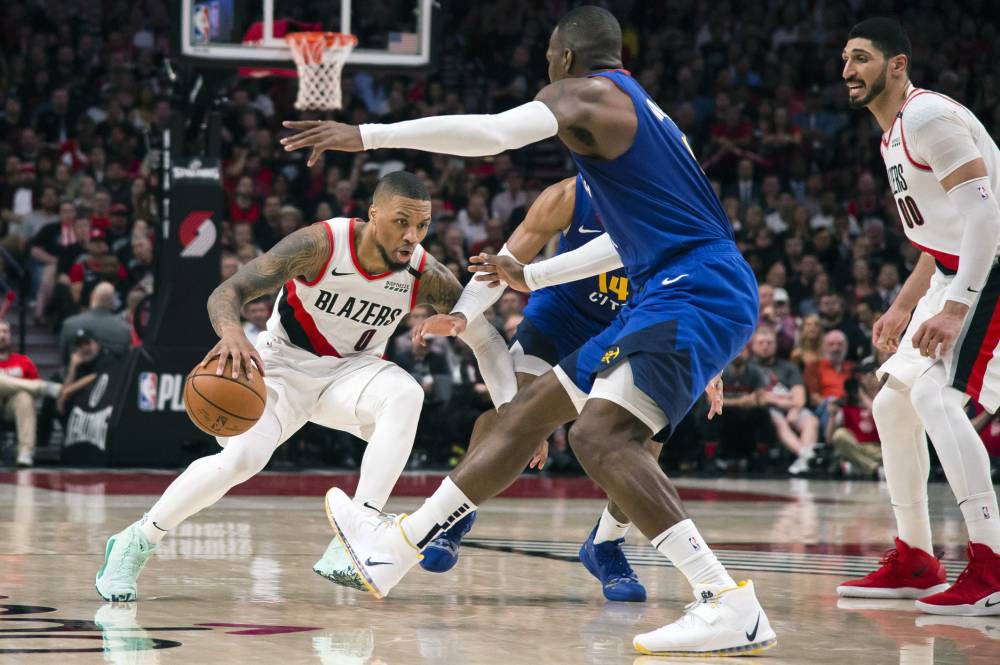  Portland Trail Blazers guard Damian Lillard (0) drives to the basket between Denver Nuggets guard Gary Harris (14) and forward Paul Millsap (4) during the second half in game six of the second round of the 2019 NBA Playoffs at Moda Center. — Reuters