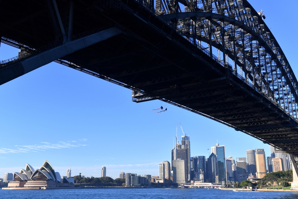 Greenpeace activists can be seen suspended from the undercarriage of the Sydney Harbor Bridge in Sydney, Australia, May 14. - Reuters 2019. 