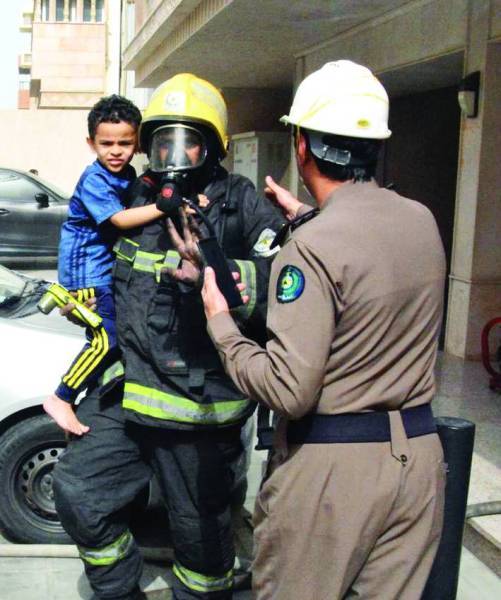 Civil Defense rescue personnel evacuate a residential building in north Jeddah following a fire.