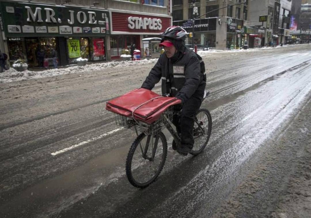A pizza delivery man rides on a bicycle on 8th avenue in New York city as the city slowly returned to normal after being hit by winter storm Juno in this file photo. – Reuters