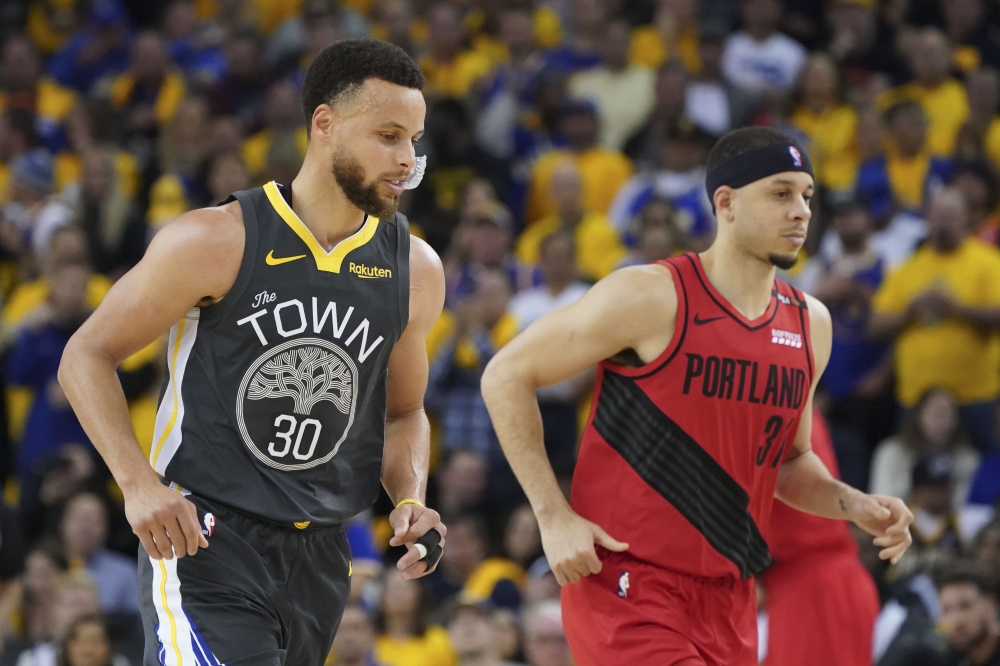 Golden State Warriors guard Stephen Curry (30) and Portland Trail Blazers guard Seth Curry (31) jog during the third quarter in game two of the Western conference finals of the 2019 NBA Playoffs at Oracle Arena. — Reuters