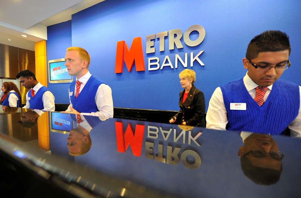 Staff serve customers at the first branch of  Metro Bank in Holborn in central London, in this file photo. — Reuters