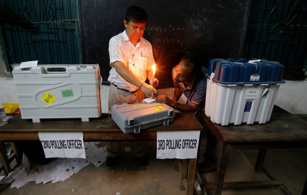 Polling officials seal an Electronic Voting Machine (EVM) and a Voter Verifiable Paper Audit Trail (VVPAT) machine at a polling station after the end of the last phase of the general election in Kolkata, India, Sunday. — Reuters