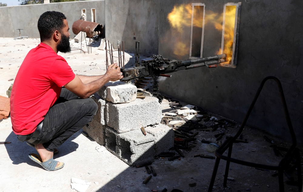A fighter loyal to Libyan internationally recognized government fires a heavy machine gun during clashes with forces loyal to Khalifa Haftar at outskirts of Tripoli, Libya, in this May 16, 2019 file photo. — Reuters