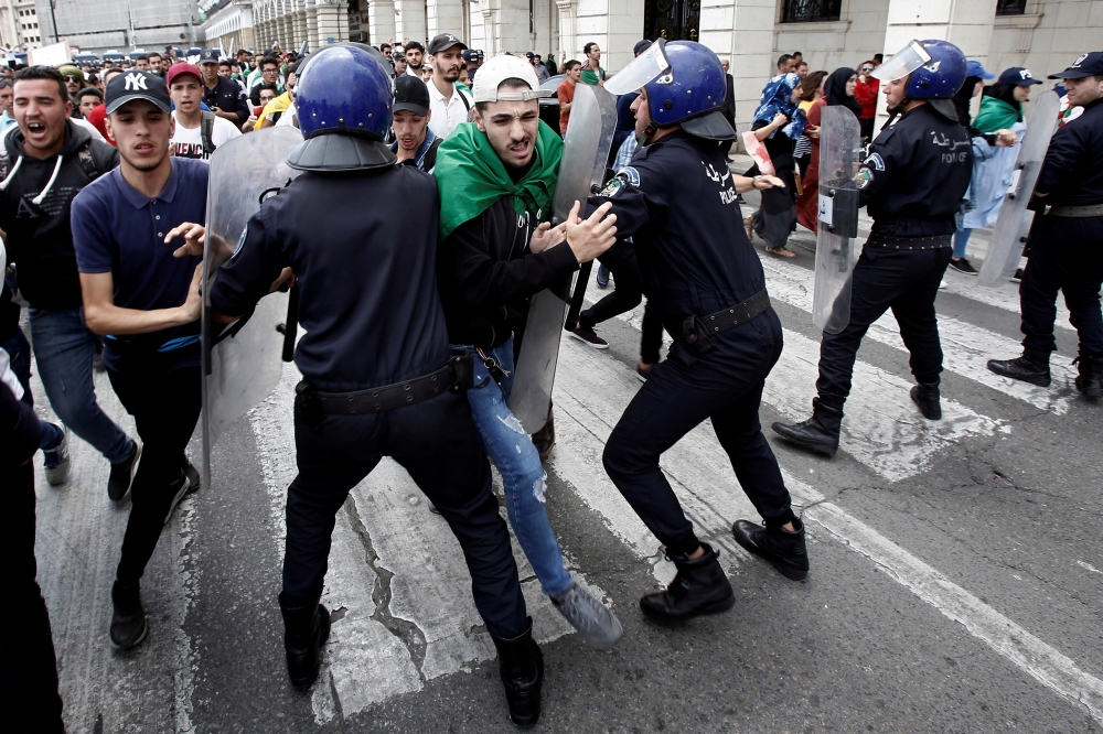 Students and police confront each other during an anti government protest in Algiers. — Reuters