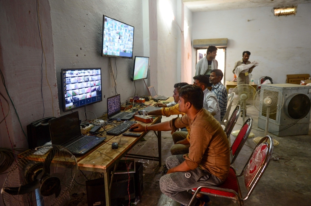 Counting agents of different political parties observe CCTV footage inside a vote counting center at Mundera Mandi where Electronic Voting Machines (EVM) are being kept on the eve of the counting day in India's general election in Allahabad, Wednesday. — AFP