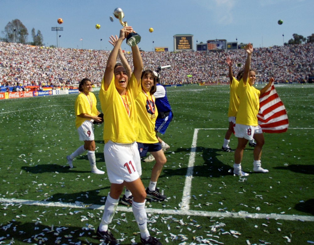Julie Foudy of the USA (C) holds up the Women's World Cup trophy after the USA beat China in the World Cup final on penalty kicks. At left is Mia Hamm (9) and at right is Shannon MacMillan, with flag in this file photo. — Reuters