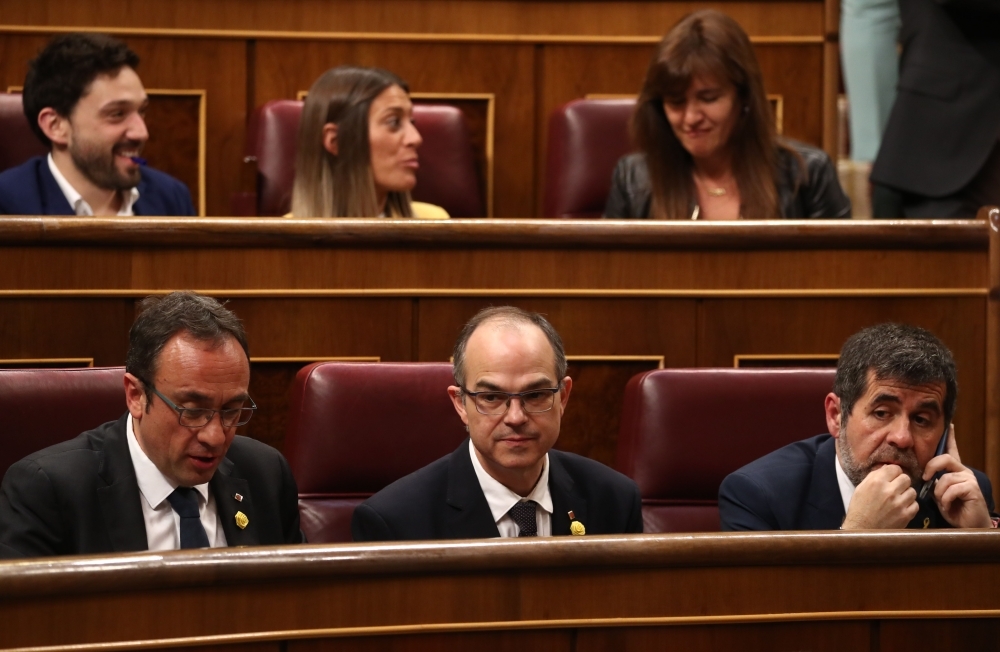 In this file photo taken on May 21, 2019 newly elected and jailed Catalan elected members of parliament JxCAT party MP Jordi Sanchez (R), Jordi Turull (C) and Josep Rull (L) attend the first plenary session of the Lower House of Parliament since last month's general election in Madrid. — AFP