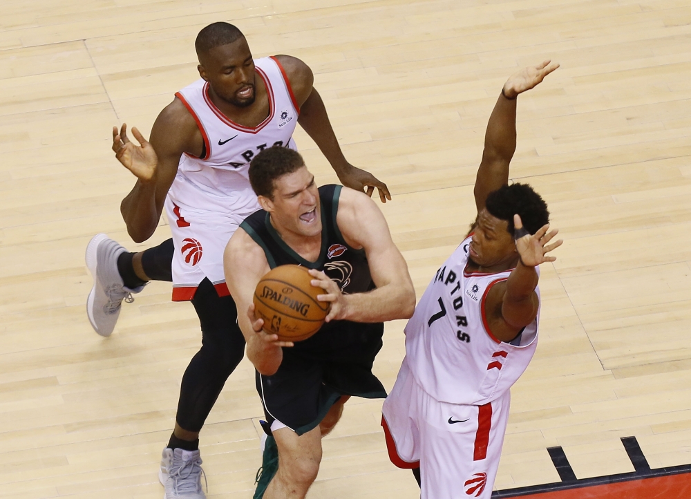 Toronto Raptors guard Kyle Lowry (7) and Raptors forward Serge Ibaka (9) defend against Milwaukee Bucks center Brook Lopez (11) during game six of the Eastern conference finals of the 2019 NBA Playoffs at Scotiabank Arena, on Saturday. — Reuters