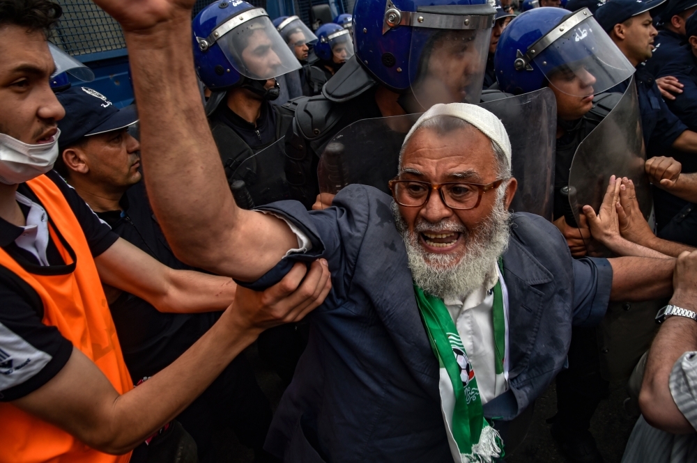 Algerian protesters gather before riot police during an anti-government demonstration outside the the Grand Post Office, a key rallying point for protesters in the capital Algiers, in this May 24, 2019 file photo. — AFP