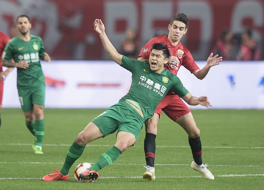Shanghai SIPG's Oscar, right, clashes with Zhang Yuning of Beijing Guoan during their Chinese Super League (CSL) football match in Shanghai on Sunday. — AFP